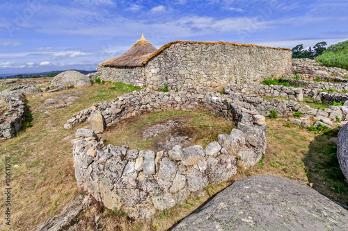 Roundhouse ruins and the reconstructed family nucleus building in Citania de Sanfins. A Castro Village (fortified Celtic-Iberian pre-historic settlement) in Pacos de Ferreira, Portugal. photo