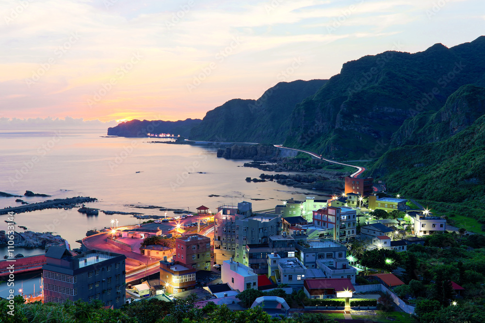 Aerial view of a fishing village and Coast Highway at dawn on northern coast of Taipei Taiwan ~ Beautiful coastal scenery under moody rosy sunrise sky Cliff coastal line road at Dawn ~