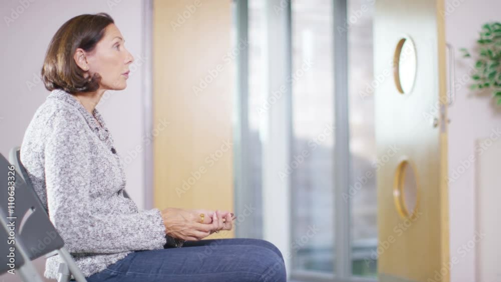 Worried woman sits alone in hospital waiting area and waits to get news from the doctor. Shot on RED Epic. Worried woman sits alone in hospital waiting area and waits to get news from the doctor. Shot on RED Epic.