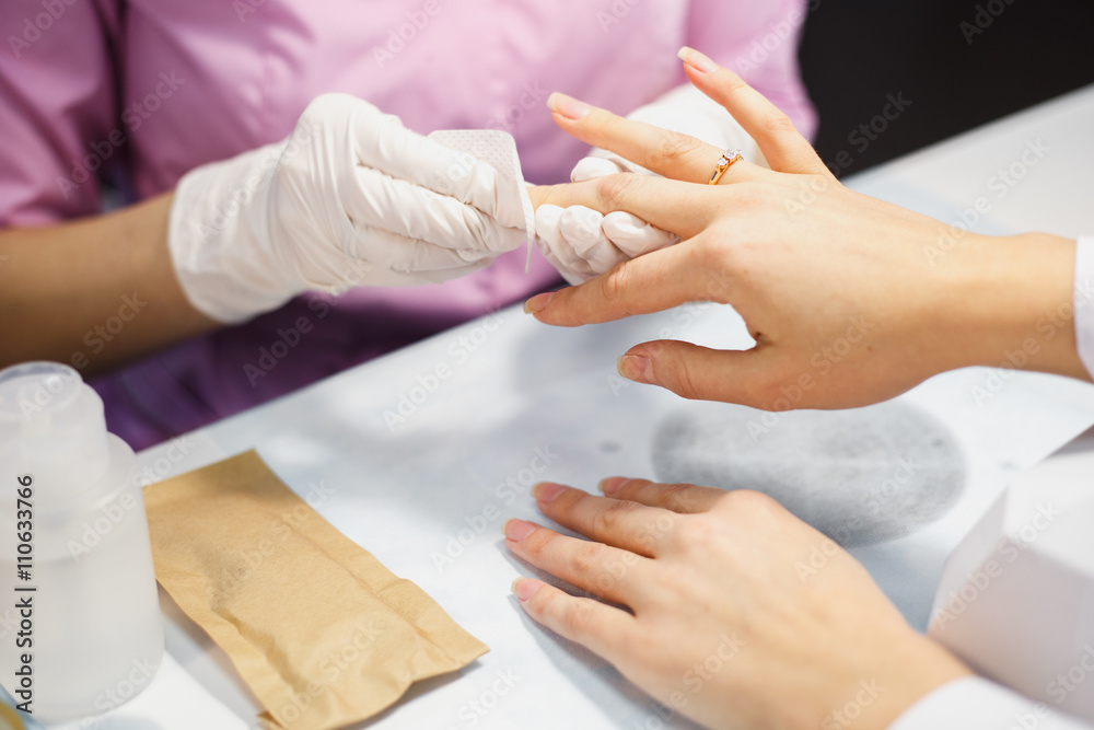 Manicure care procedure, Close-up photo Of Beautician Hand Painting Nails Of Woman In Salon Manicure care procedure, Close-up photo Of Beautician Hand Painting Nails Of Woman In Salon