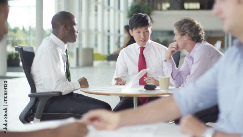 Mixed ethnicity business group chatting in large modern office building Mixed ethnicity business group chatting in large modern office building