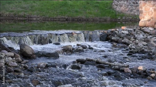 the threshold with the raging water on the rocks in the river in the forest photo