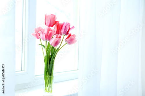 Pink tulips in vase on the windowsill
