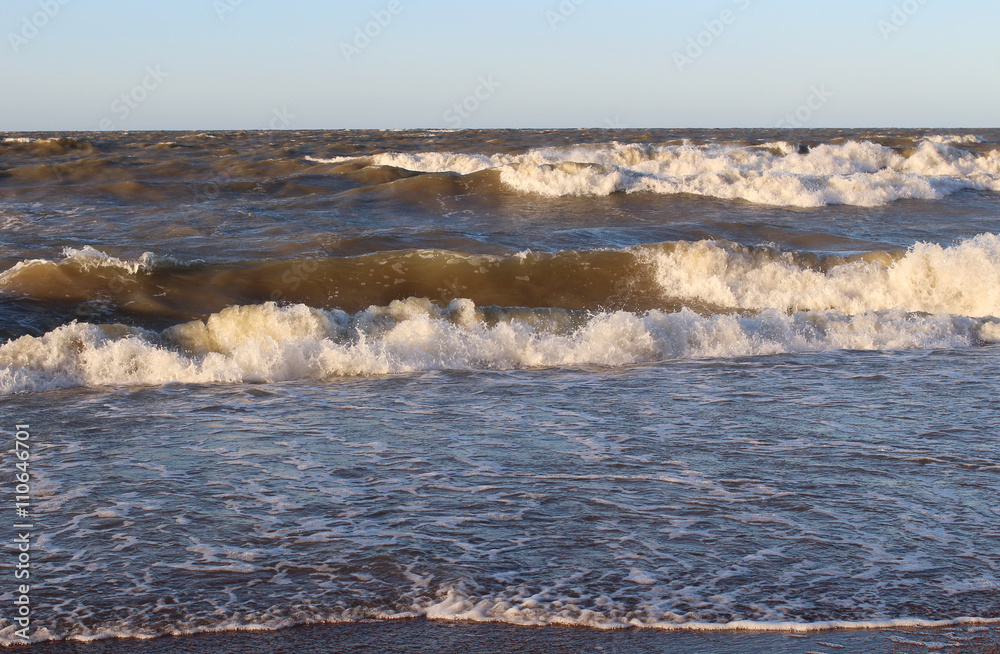 Large waves of the sea and the sandy beach