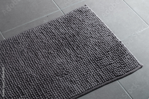 Fluffy grey doormat on the grey floor
