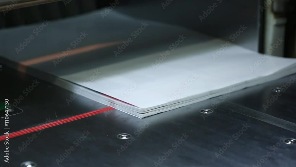 Modern paper guillotine with touch screen used in commercial printing industry. By machinery warning sign pasted on safety. Modern paper guillotine with touch screen used in commercial printing industry. By machinery warning sign pasted on safety.