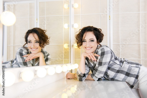 Girl near the mirror. Young girl in a beauty salon 