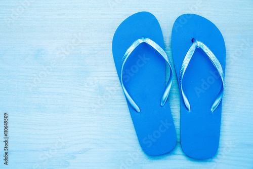 Color flip flops on blue wooden background