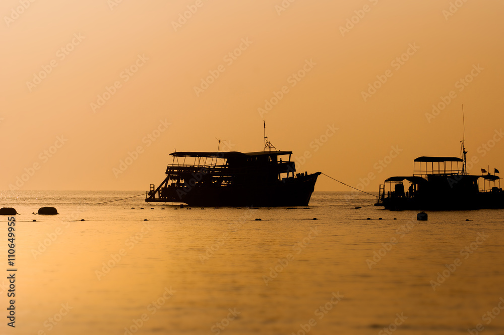 Fototapeta premium Silhouette of cruise ship at sunset in a sea