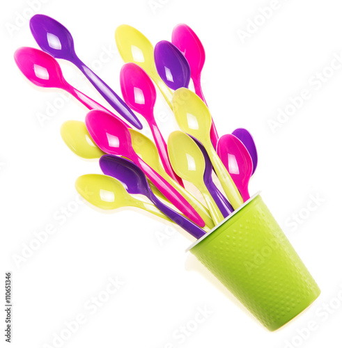 Photos Multi-colored plastic spoons in the single cup isolated on white