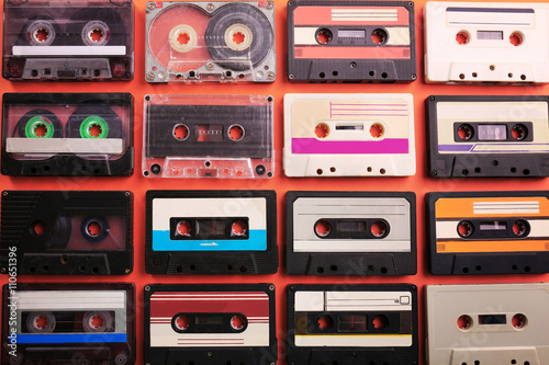 Set of old audio cassettes on red background
