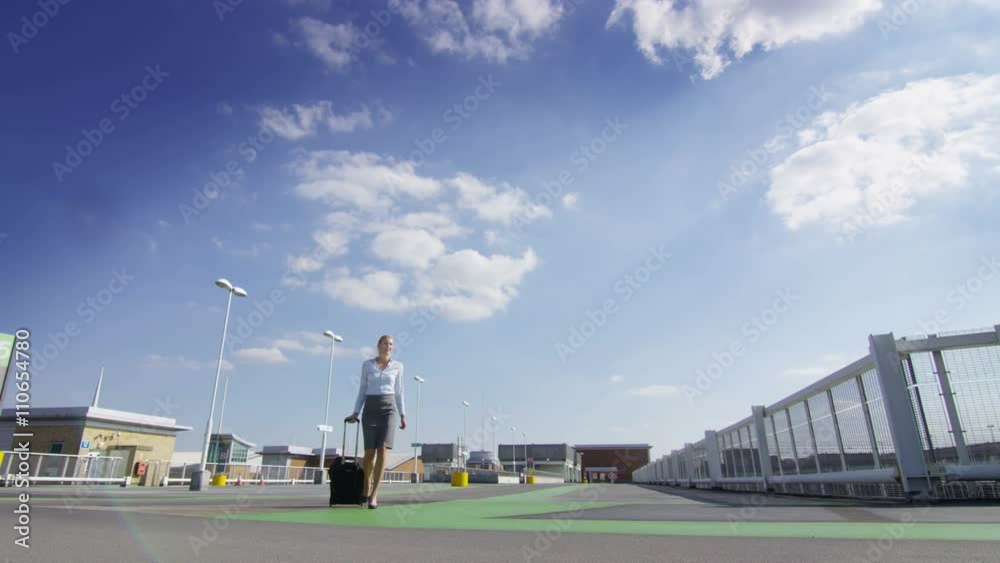 Beautiful businesswoman traveling - walking with luggage at airport car park. Beautiful businesswoman traveling - walking with luggage at airport car park.