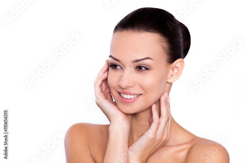 Natural spa. Beautiful young shirtless woman holding hands under chin while standing against white background