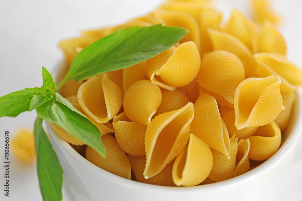 Fresh uncooked pasta in bowl on wooden table closeup Fresh uncooked pasta in bowl on wooden table closeup