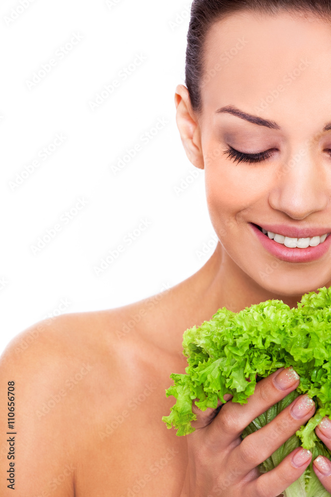 Healthy food for a natural beauty. Cropped shot of an attractive young woman holding a leafs of salad and smile over white isolated background Healthy food for a natural beauty. Cropped shot of an attractive young woman holding a leafs of salad and smile over white isolated background
