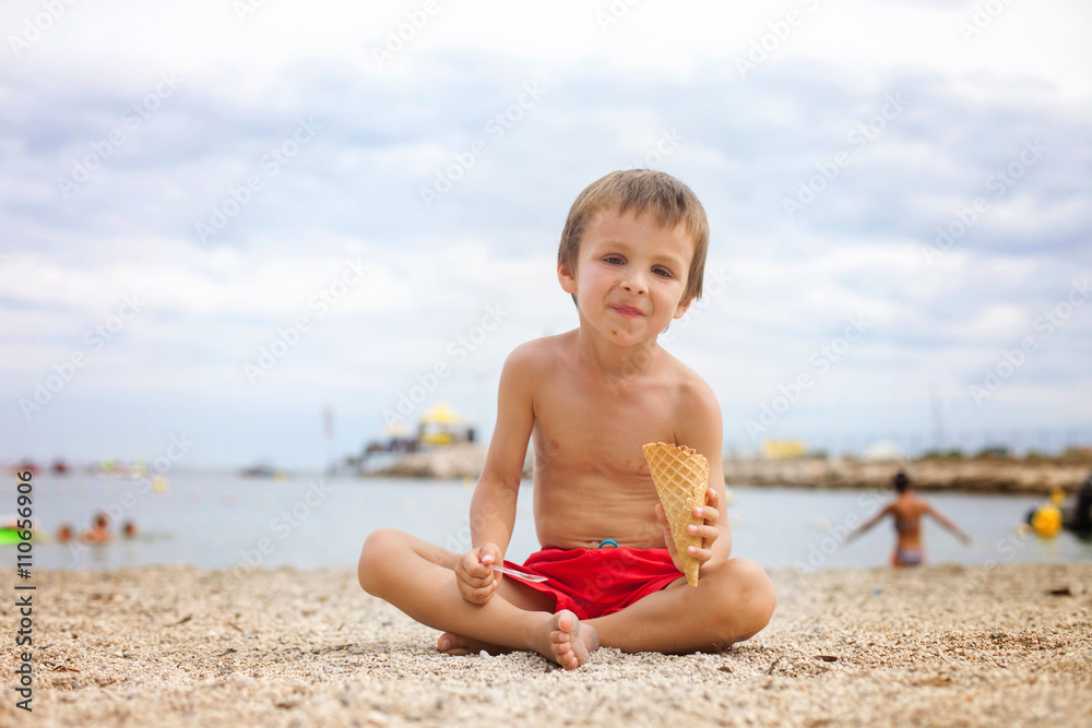 Sweet little child, boy, eating ice cream on the beach Sweet little child, boy, eating ice cream on the beach