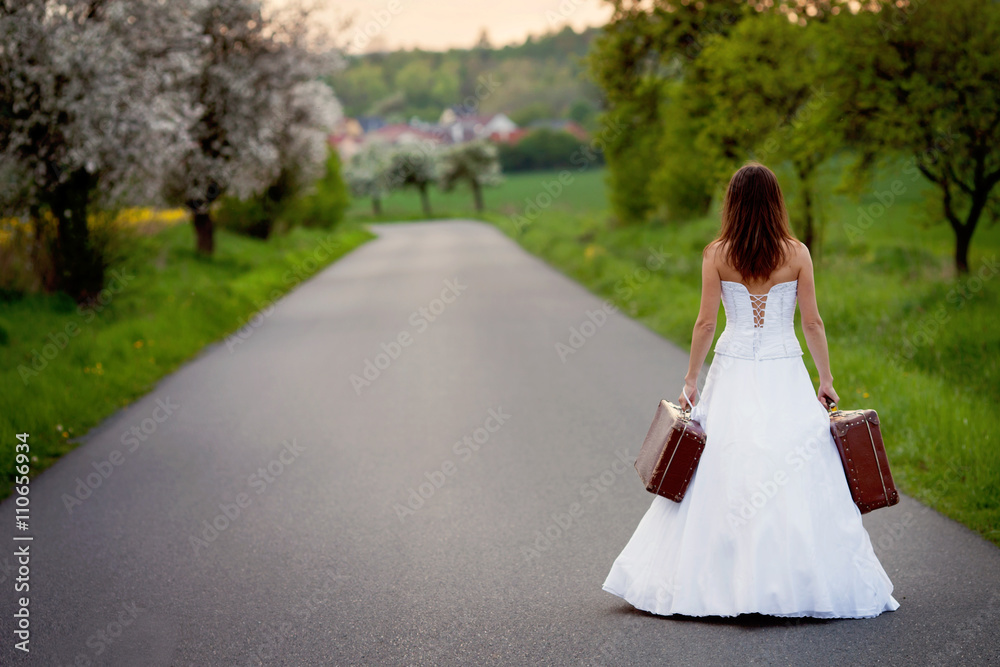Young bride on the road with a suitcase