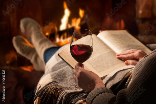Woman reads book near fireplace © Alexander Raths