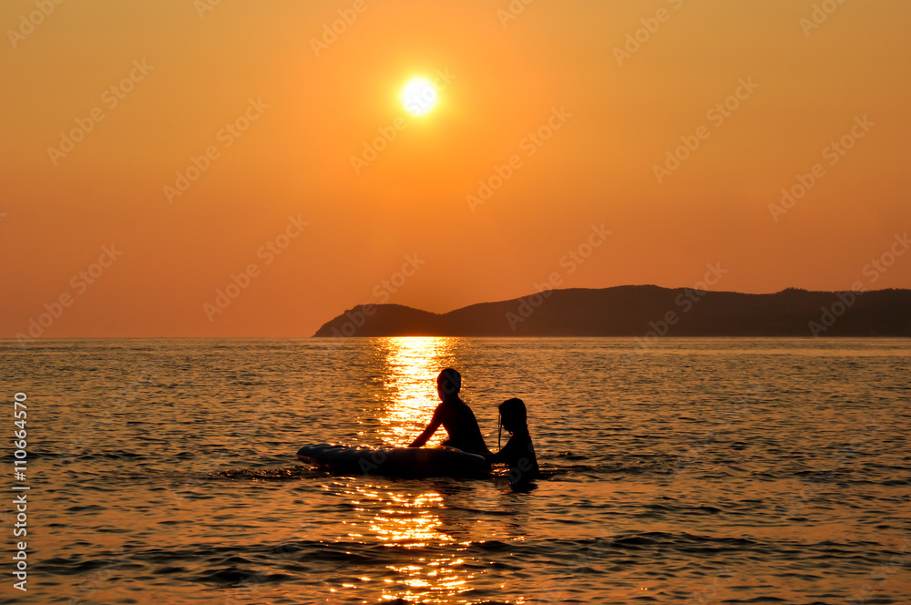 Seaside and children playing at sunset