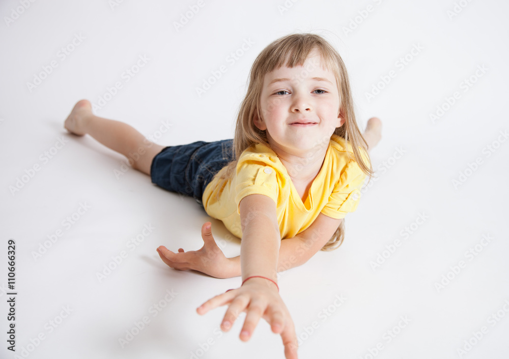Smiling little girl lying on the floor and reaching out her hand Smiling little girl lying on the floor and reaching out her hand