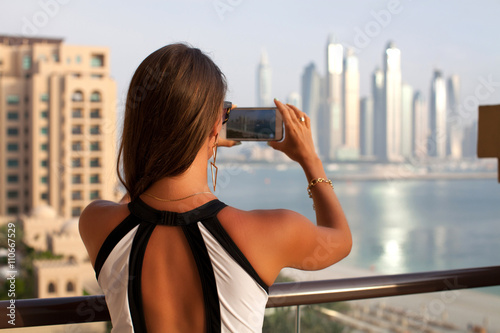 Beautiful travel woman taking photo photographing using smart ph
