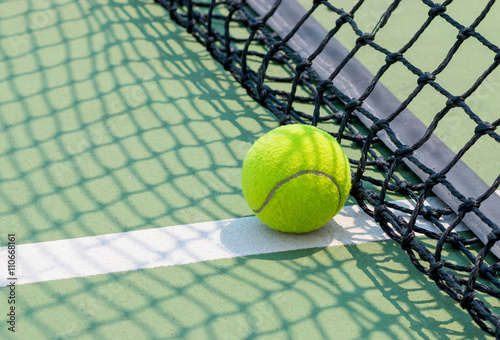 Tennis ball on green tennis court © smolaw11
