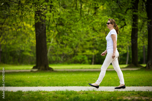 Middle-age woman walking in city park