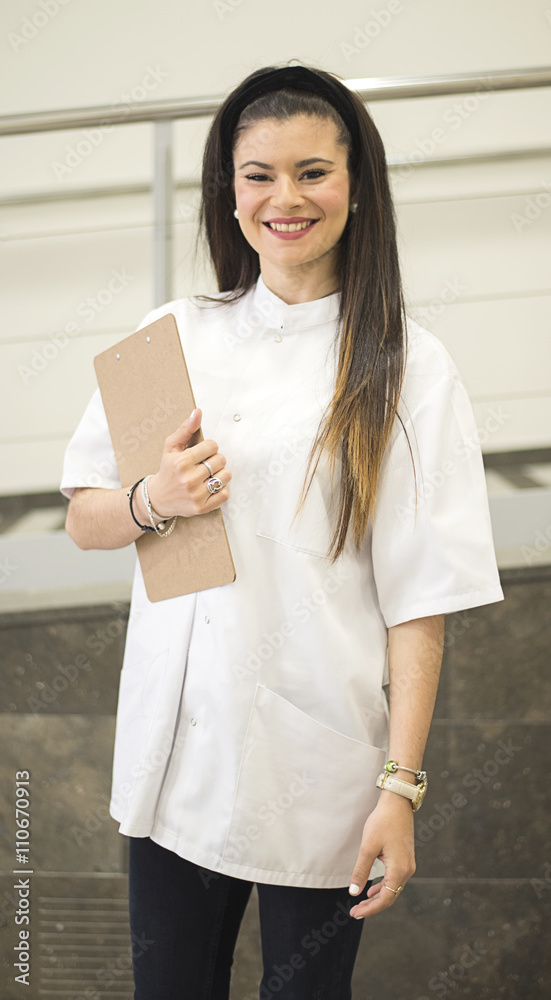 Nurse smiles looking at camera while holding a folder Nurse smiles looking at camera while holding a folder