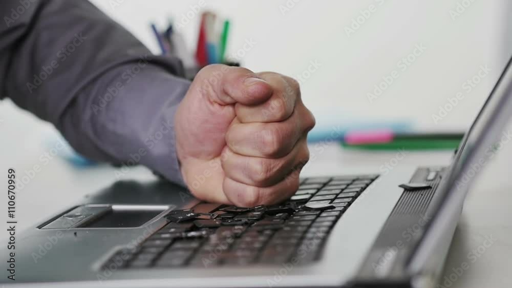 angry man smashing destroying computer keyboard with fist slow motion
