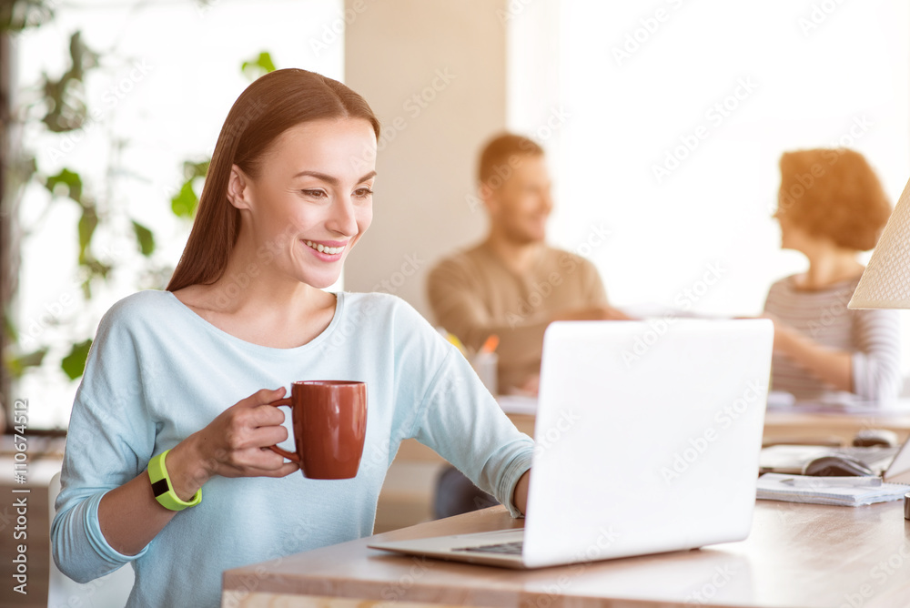 Pleasant smiling woman using laptop Pleasant smiling woman using laptop