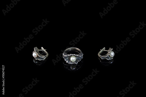 Ring and earrings of silver in the form of oysters with pearls on a black background