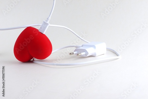 Red heart on charging on a white background