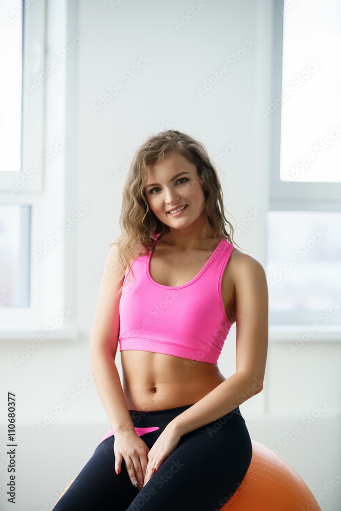 Shot of smiling young woman posing in fitness room