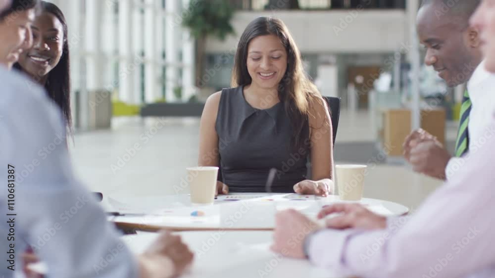  Attractive mixed ethnicity business group discuss ideas in office meeting