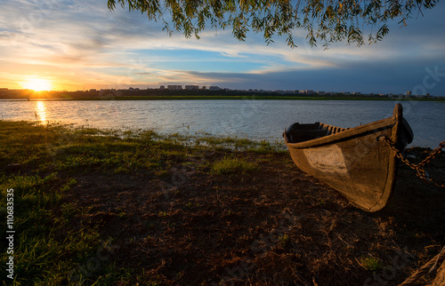 Tablou pe pânză Old fishing boat at sunset
