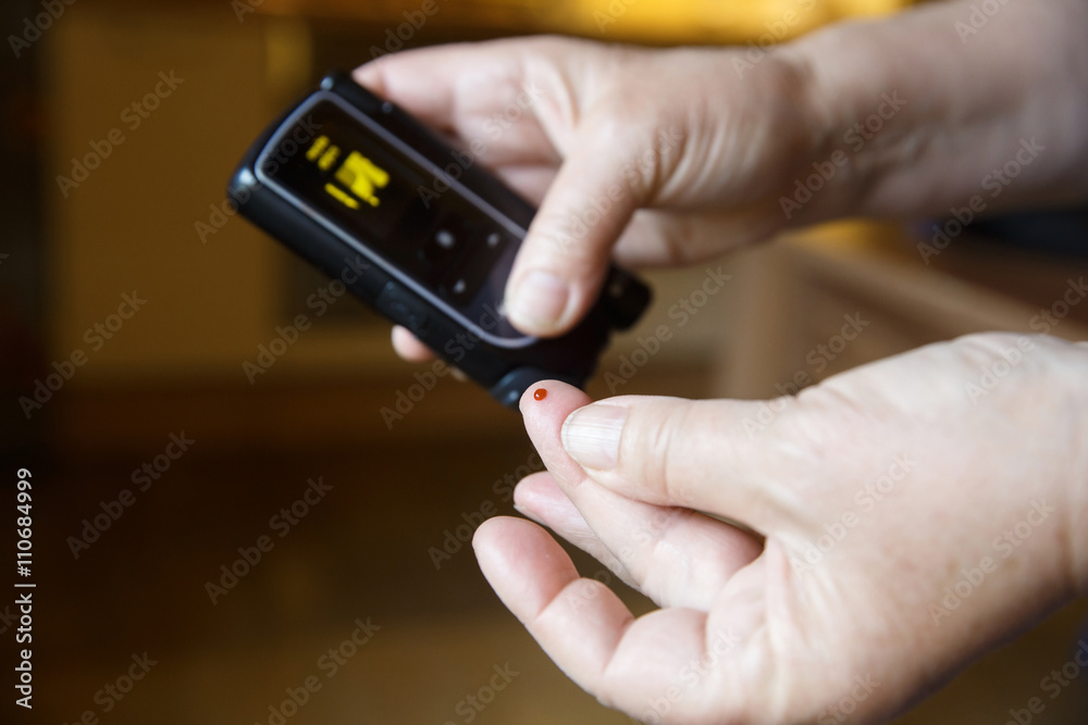 Diabetic patient testing her blood for sugar level