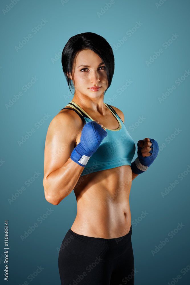 Young sportive woman with dumbbells at blue background Young sportive woman with dumbbells at blue background