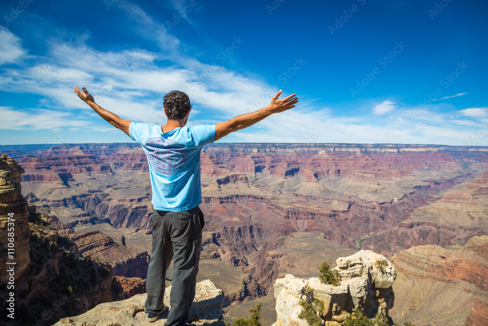 Grand Canyon, Arizona - March 21st 2014 - A young man observing the huge canyon in front of him in south rim of the Grand Canyon National Park, Arizona, USA Grand Canyon, Arizona - March 21st 2014 - A young man observing the huge canyon in front of him in south rim of the Grand Canyon National Park, Arizona, USA