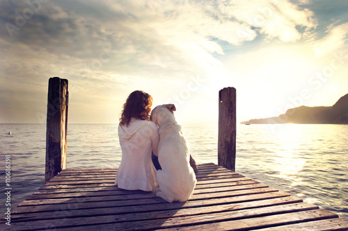 Fotografie dog rests gently on his master's shoulder while looking the view
