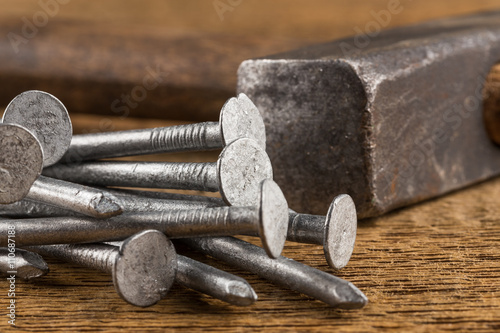 Vintage hammer with nails on wood background