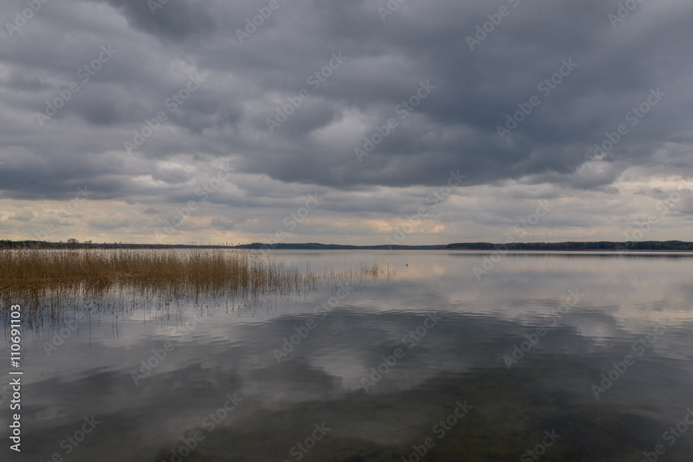 dark clouds in the stormy sky reflecting on the surface of calm forest lake
Absterna lake, Braslaw, Belarus