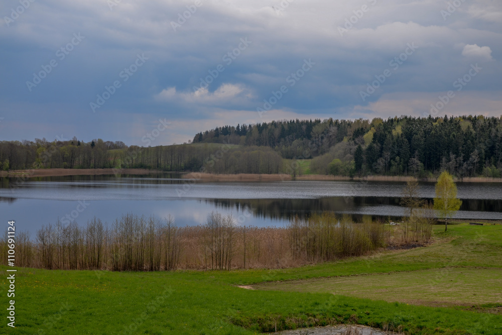 green fields and wooded hills surrounding forest lake
Ilmenek lake, Braslaw, Belarus