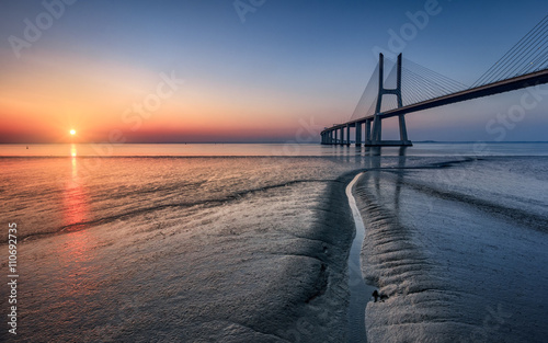 Sunrise at Vasco da Gama bridge with low tide