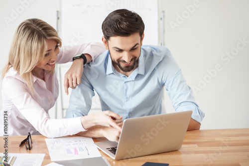 Cheerful two workers are talking in office