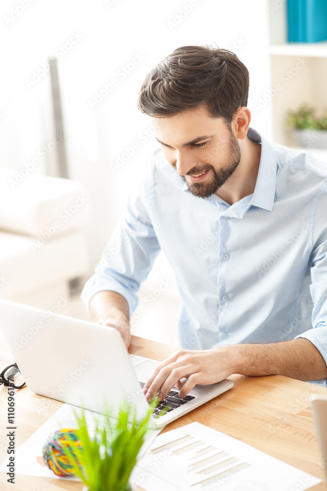Handsome young businessman is typing on computer Handsome young businessman is typing on computer