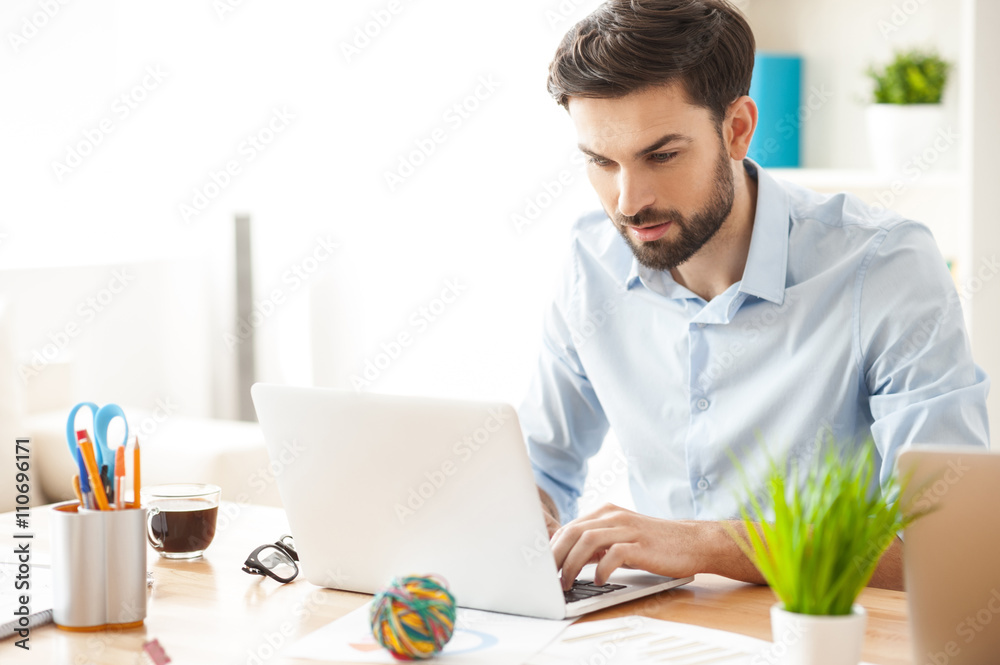 Cheerful male worker is using modern technology Cheerful male worker is using modern technology