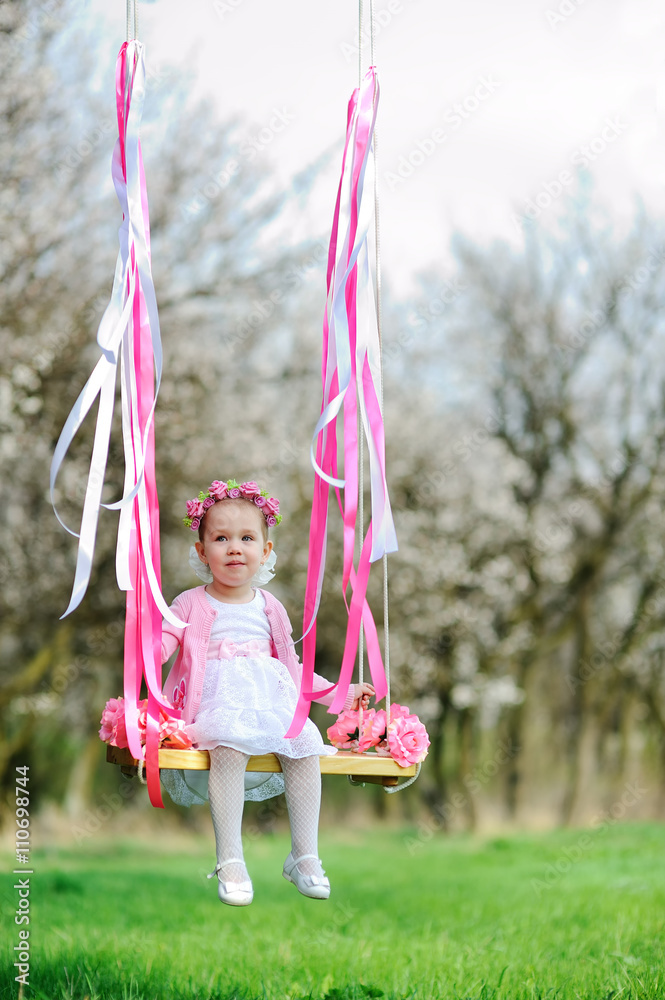little girl in a beautiful dress riding on a swing. Stock Photo | Adobe ...