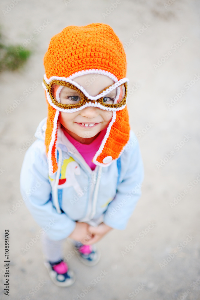 baby girl in pilot hat smiling at the camera baby girl in pilot hat smiling at the camera