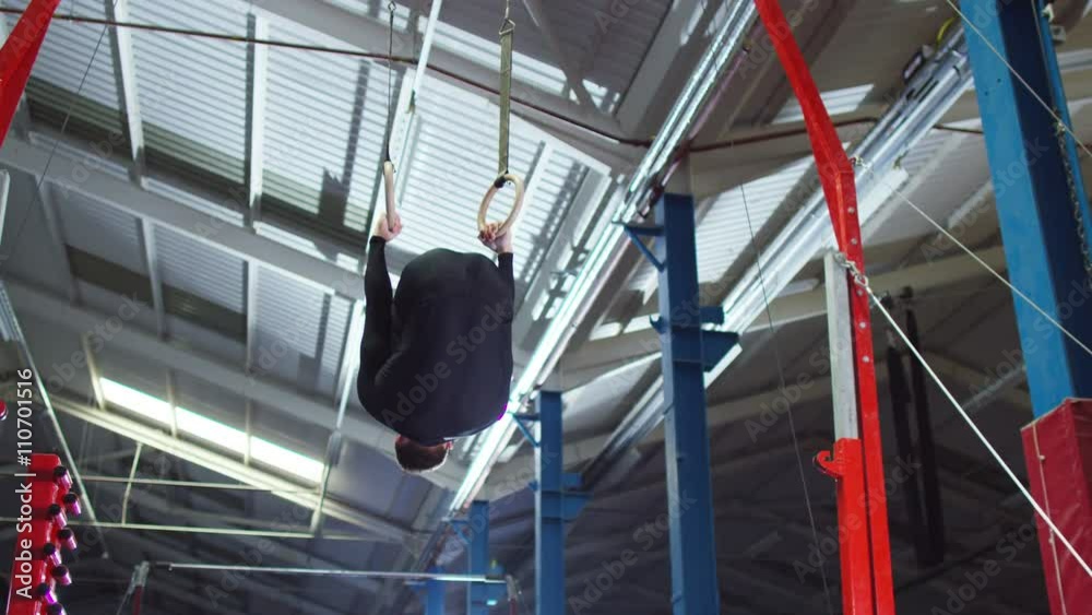Professional male gymnast training on the rings at the gym. Professional male gymnast training on the rings at the gym.