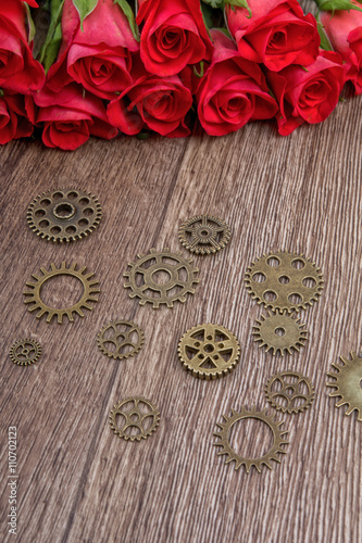 Roses and gears on a wooden background